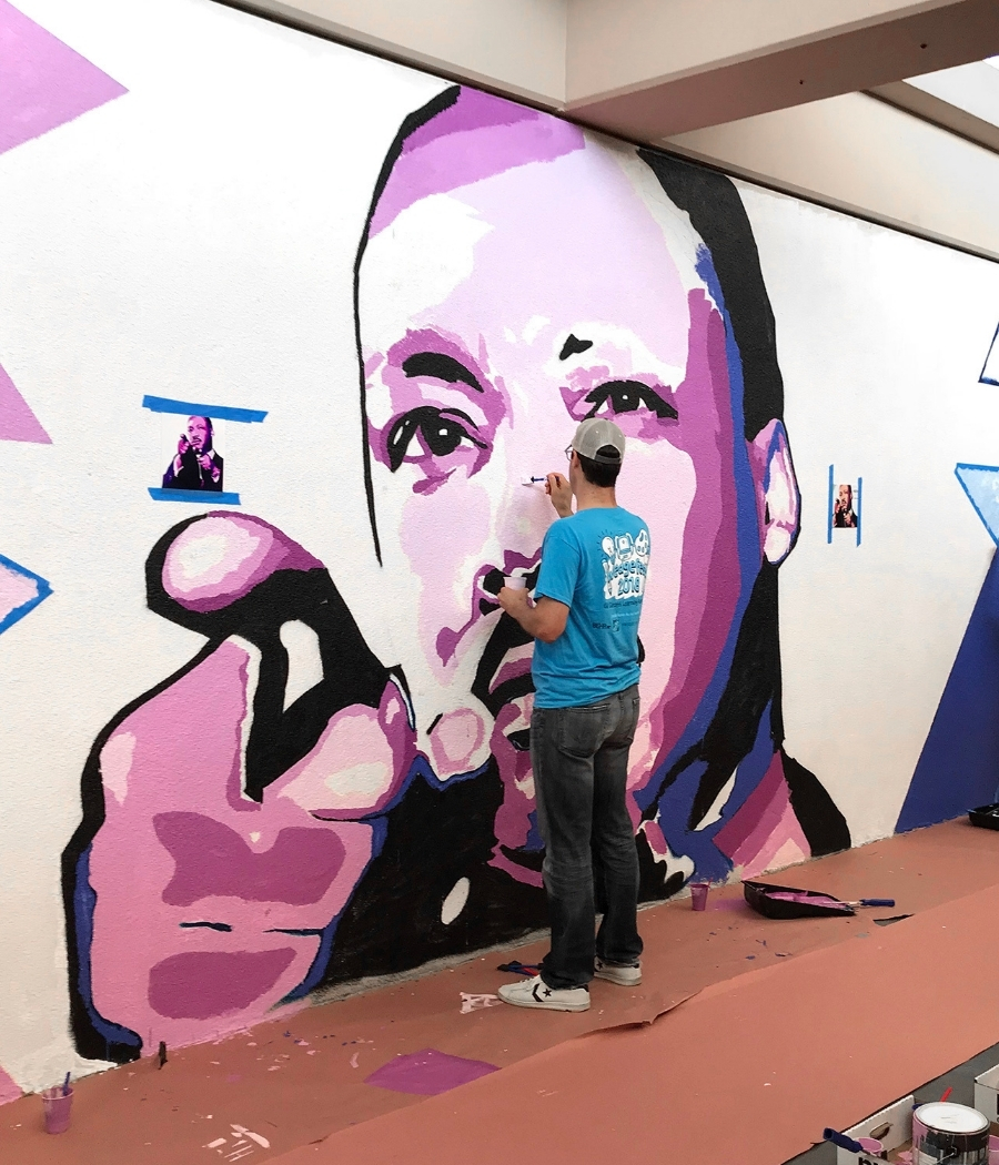 Volunteer painting a mural at Gil Garcetti Learning Academy during Wedgefest community service day in South Los Angeles